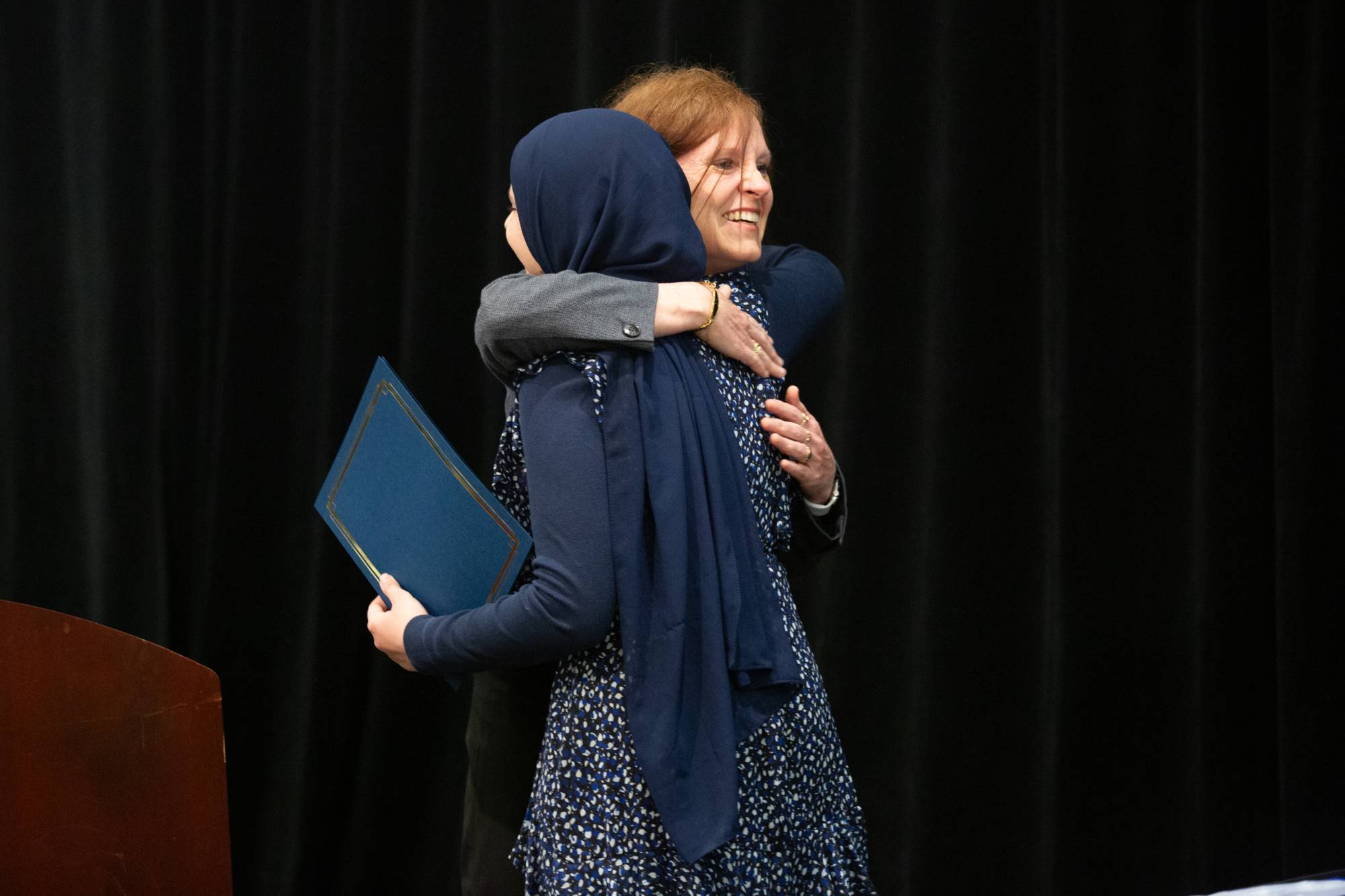 Professor Coeli Fitzpatrick hugs graduating student.